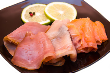 Trio of smoked fish on plate on white background seen close