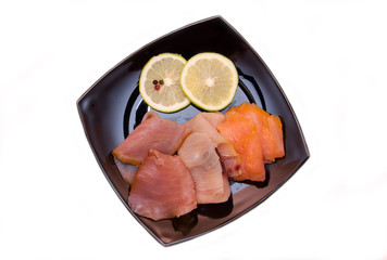 Trio of smoked fish on plate on white background seen from above