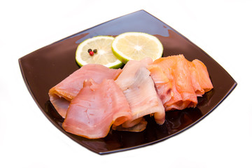 Trio of smoked fish on plate on white background