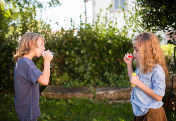 Boy and girl blowing soap bubbles