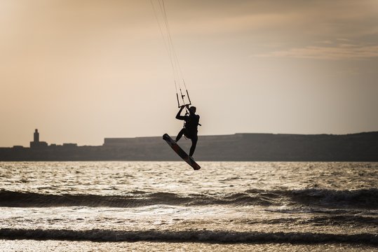 silhouette of a kite surfer at the beach