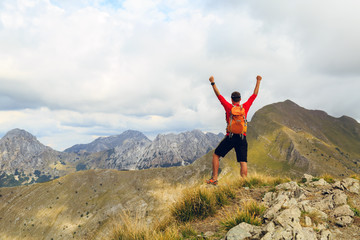 Hiking success, man runner in mountains