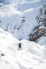 Fototapeta na wymiar Woman hiking in white winter mountains