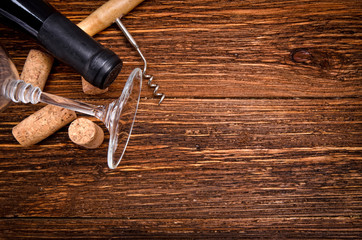 Fototapeta na wymiar Bottle of wine, corkscrew and corks on wooden table. Background