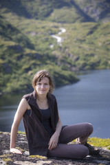 Fototapeta na wymiar junge Frau rastet an einem Bergsee auf den Lofoten, Norwegen