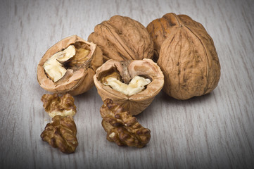 walnuts in shell and open on wood gray table