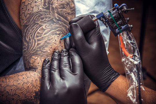 Professional tattooer making a tattoo in studio