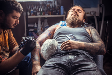 Tattoo specialist makes tattoo pictures in tattoo studio