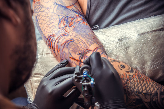 Professional tattooist makes tattoo in tattoo parlour