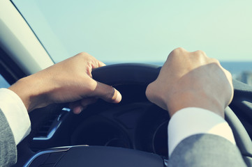 young man in suit driving a car, filtered