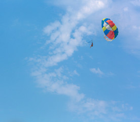 Fototapeta na wymiar Some people parasailing over the sea