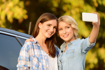 Pleasant girls standing near car 