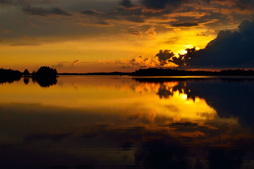 Orange mirror sunset. Lake Pongoma, North Karelia, Russia