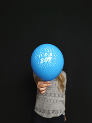 Caucasian woman standing in front of a dark chalkboard. The chal