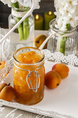 Jar of peach jam and hyacinth flowers in the background