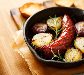Roast sausage with onions and rosemary
