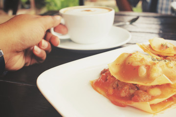 Italian lasagna with coffee cup