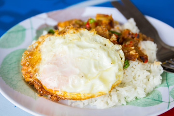 Spicy crispy pork puff with basil and fried egg.