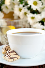 coffee with candies, lemon water and white flowers