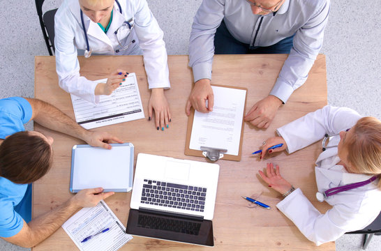 Male and female doctors working on reports in medical office