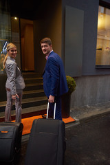 business people couple entering  hotel