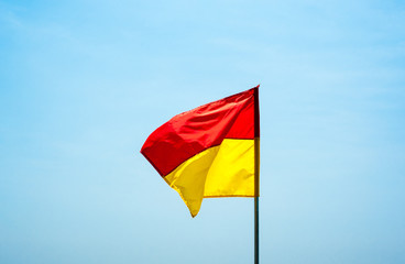 Red and yellow swimming safety flag flapping