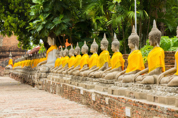 Aligned Buddha statues at Wat Yai Chaimongkol, Ayutthaya, Thailand. - obrazy, fototapety, plakaty