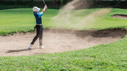 Yong asian golfer explosion sand.