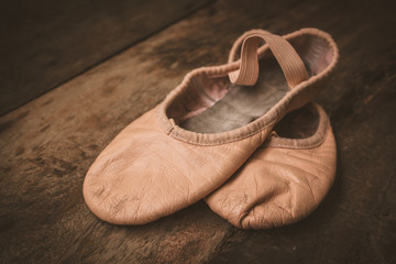 Ballet shoes on wooden floor.