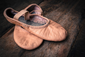 Ballet shoes on wooden floor.