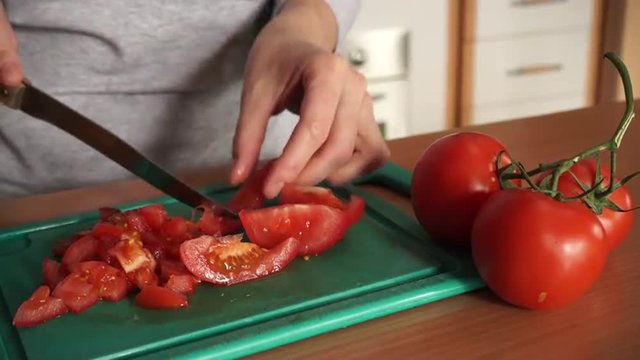 Female hands cutting fresh tomato vegetable 4K