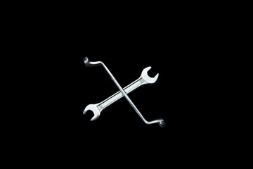 wrench in cross symbol and in black background