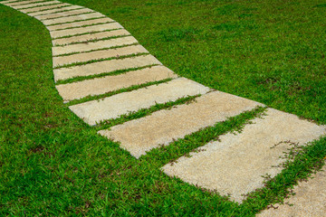Gardening stone footpath with grass in the garden