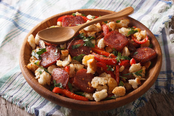 migas with chorizo, bread crumbs and vegetables close-up, horizontal
