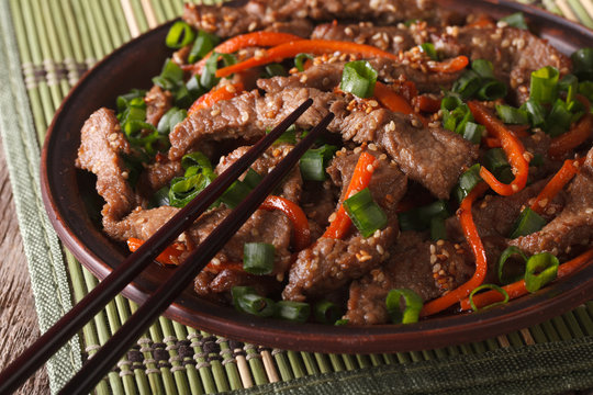 slices of beef fried with sesame seeds and carrots closeup. horizontal