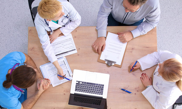 Male and female doctors working on reports in medical office