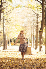 Beautiful woman enjoying a walk in the park in autumn