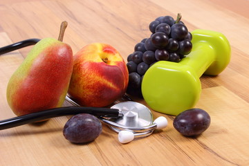 Medical stethoscope, fruits and dumbbells for using in fitness