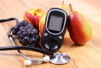 Glucose meter with medical stethoscope and fresh fruits