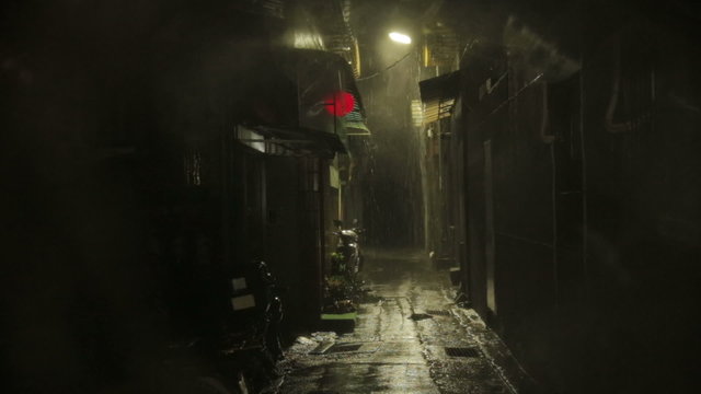 Alleyway with Chinese lantern blowing in wind heavy rain
