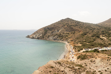 Fototapeta na wymiar Kalogeros beach at Paros island with tourists and local people enjoying their summer vacations.