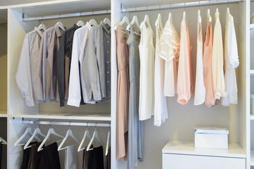 row of white dress and shirts hanging in white wardrobe