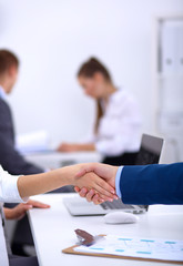 Business people shaking hands, finishing up a meeting, in office