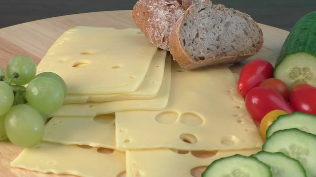 Sliced delicious edam cheese on wooden board  

