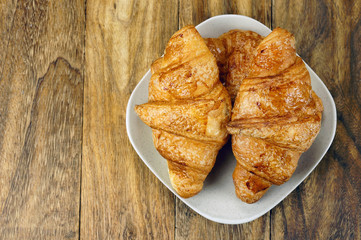 Croissant ready for breakfast on wooden table