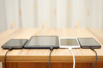 computer tablet and mobile phones charging on home desk © Bacho Foto