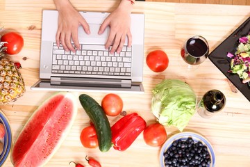 Woman using a Laptop while cooking