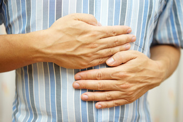 Stomach ache, man placing hands on the stomach, concept of ..sto
