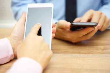 Business people using smart mobile phones at office