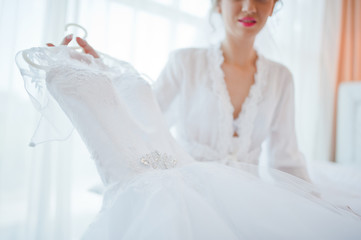 Naklejka premium gentle blonde bride on couch with wedding dress
